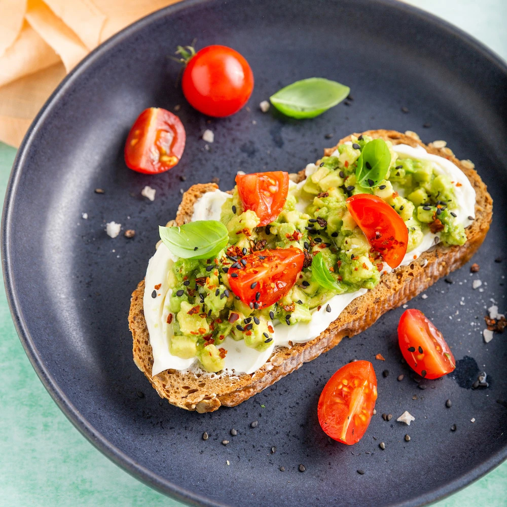 tostadas con queso vegadelphia, aguacate y topping de cáñamo.