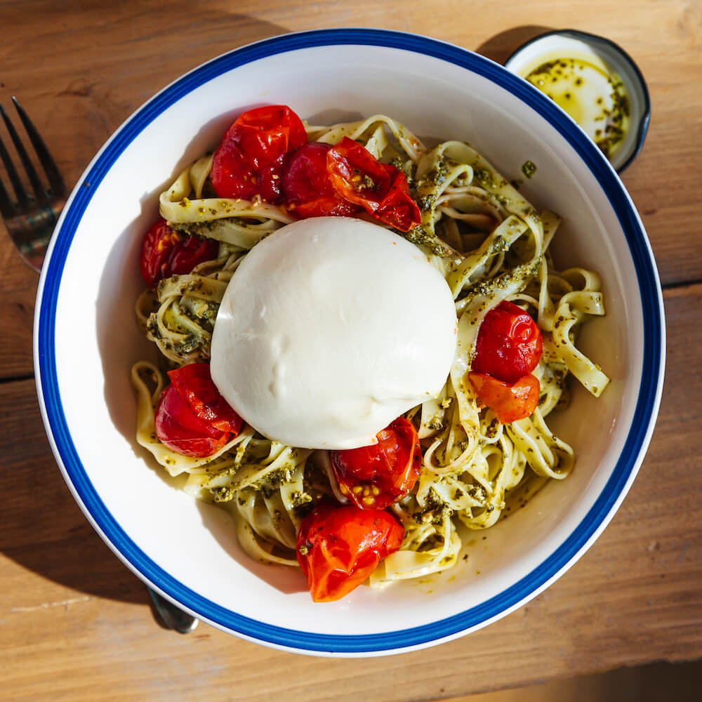 Espaguetis al pesto verde con burrata y tomate